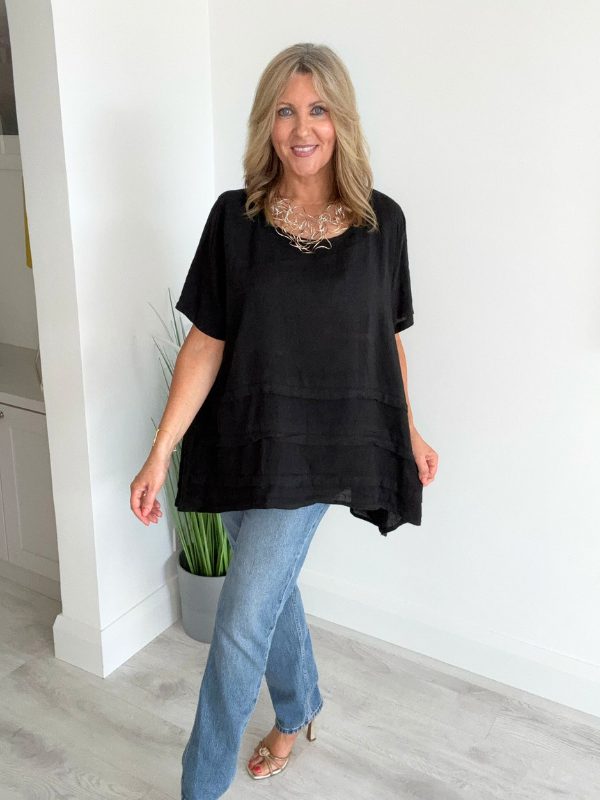 Woman wearing a vintage relaxed fit 100% linen top with short sleeves and oversized silhouette