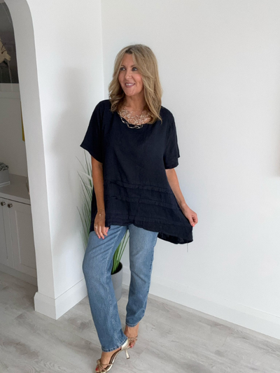 Woman wearing a vintage relaxed fit 100% linen top with short sleeves and oversized silhouette