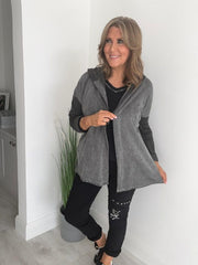 Woman wearing a velour zip-up hoodie jacket with pockets and embroidered detail, styled with matching joggers and a white top.