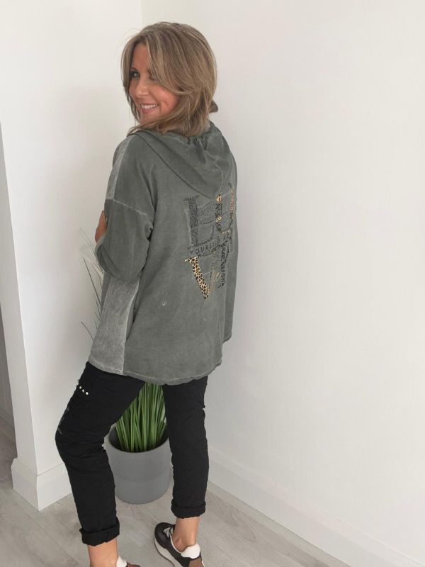 Woman wearing a velour zip-up hoodie jacket with pockets and embroidered detail, styled with matching joggers and a white top.