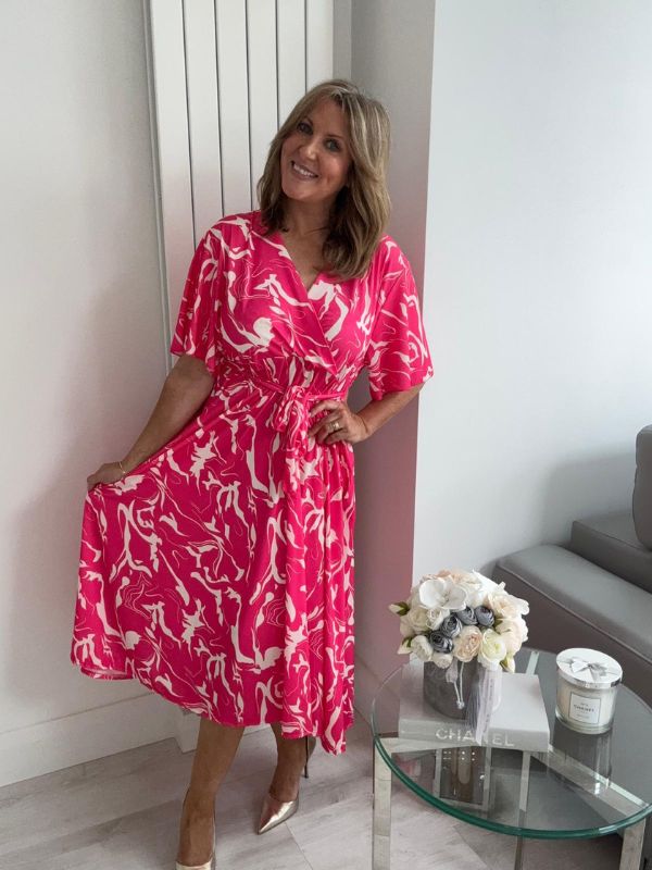 Lightweight bold pink abstract wrap dress for UK sizes 14–24 styled with heels
