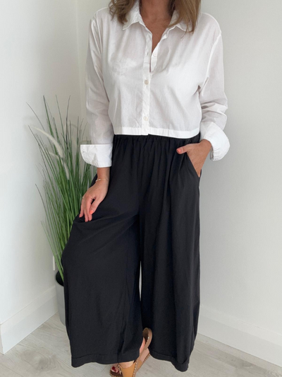 Model wearing wide-leg trousers with elastic waistband and side pockets – relaxed fit and ankle length