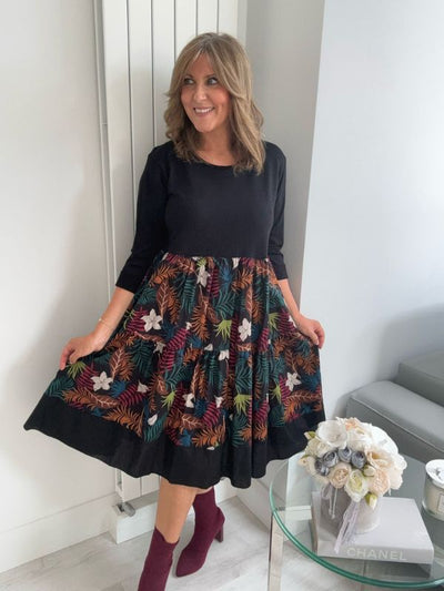 Black floral tiered midi dress with 3/4 sleeves, soft stretch top, and multi-coloured leaf and flower print skirt, fits UK sizes 8–18.