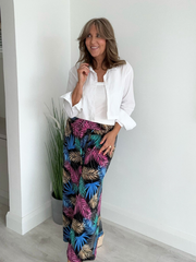 High-waisted tropical pants with elasticated waistband and flowing silhouette – styled with a white tank top