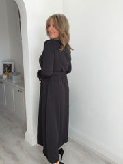 Woman wearing a Black button-down belted maxi shirt dress with long sleeves.