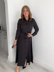 Woman wearing a Black button-down belted maxi shirt dress with long sleeves.
