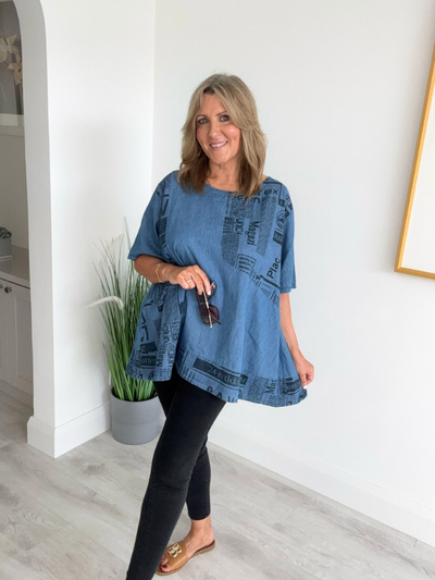 Vintage oversized denim blouse with abstract newspaper print on sleeves, round neckline, and high-low hem – 100% cotton, free size 8–20
