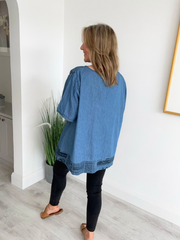 Vintage oversized denim blouse with abstract newspaper print on sleeves, round neckline, and high-low hem – 100% cotton, free size 8–20