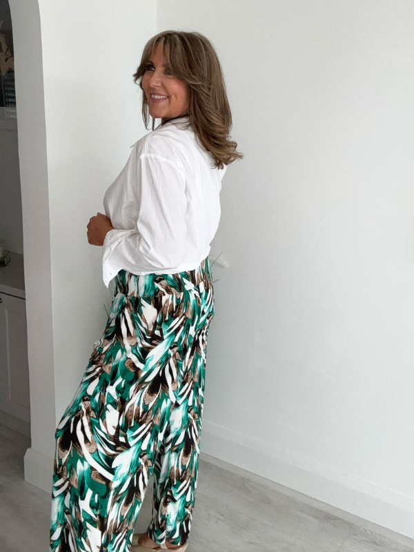 High-waisted tropical pants with elasticated waistband and flowing silhouette – styled with a white tank top