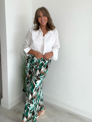 High-waisted tropical pants with elasticated waistband and flowing silhouette – styled with a white tank top