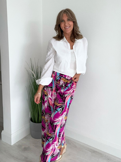 High-waisted tropical pants with elasticated waistband and flowing silhouette – styled with a white tank top