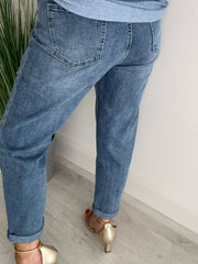 Light blue Melly mom jeans with high-waist fit, light distressing, rolled hem, and classic 5-pocket design, displayed folded on a neutral background.
