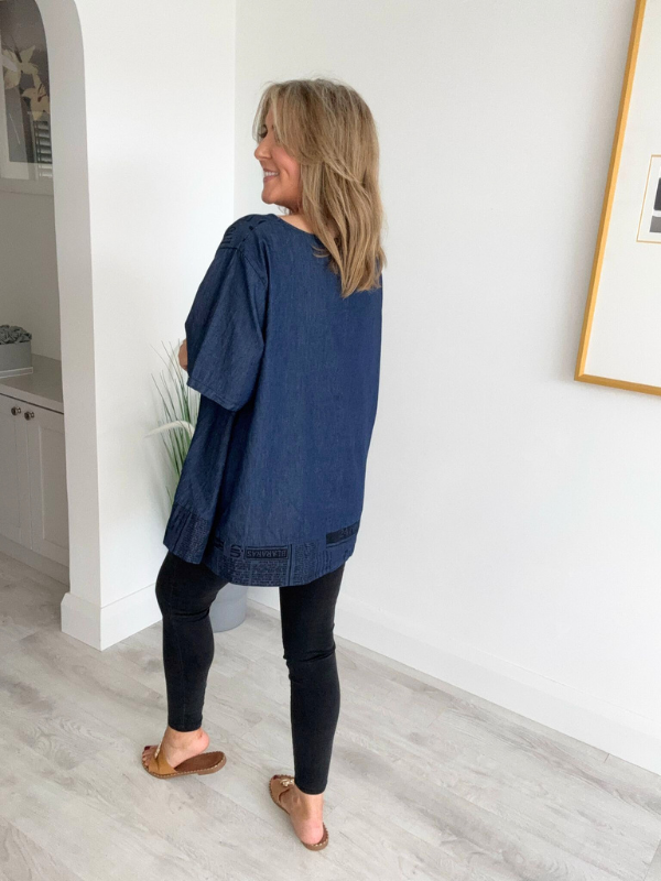 Vintage oversized denim blouse with abstract newspaper print on sleeves, round neckline, and high-low hem – 100% cotton, free size 8–20