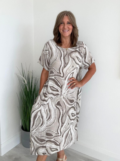 Woman wearing neutral beige cotton midi dress with abstract swirl print – one size fits 8–18