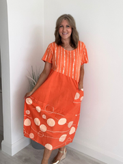 Bright orange boho-style midi dress with asymmetrical panels and short sleeves – breathable cotton