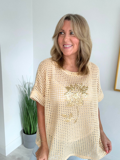 Model wearing a lightweight mesh summer top with gold floral foil print, short sleeves, and a relaxed fit – available in cream, blush pink, white, rose, grey, and mint green, fits UK sizes 8–18