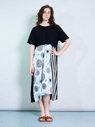 Model wearing a midi-length t-shirt dress with graphic print panel and side slit, styled in a relaxed fit
