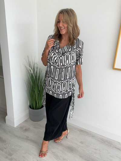 Model wearing a black-and-white geometric print drape top with a cowl neckline and asymmetrical sides, designed for a relaxed and flattering fit for UK sizes 8–16