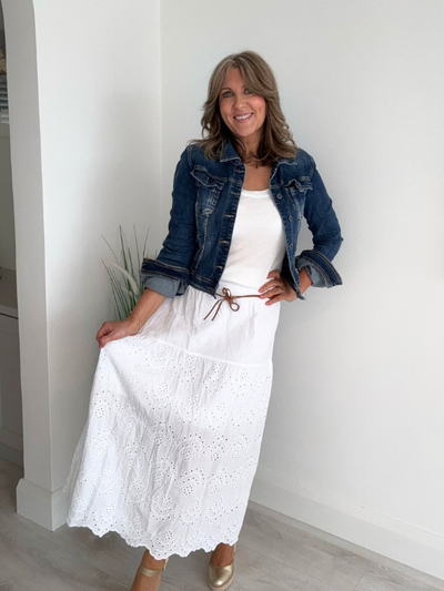 Boho-style cotton skirt with broderie anglaise embroidery, scalloped hem, and leather tie belt – available in blush pink, bright fuchsia, and white – fits EU sizes 8–14.